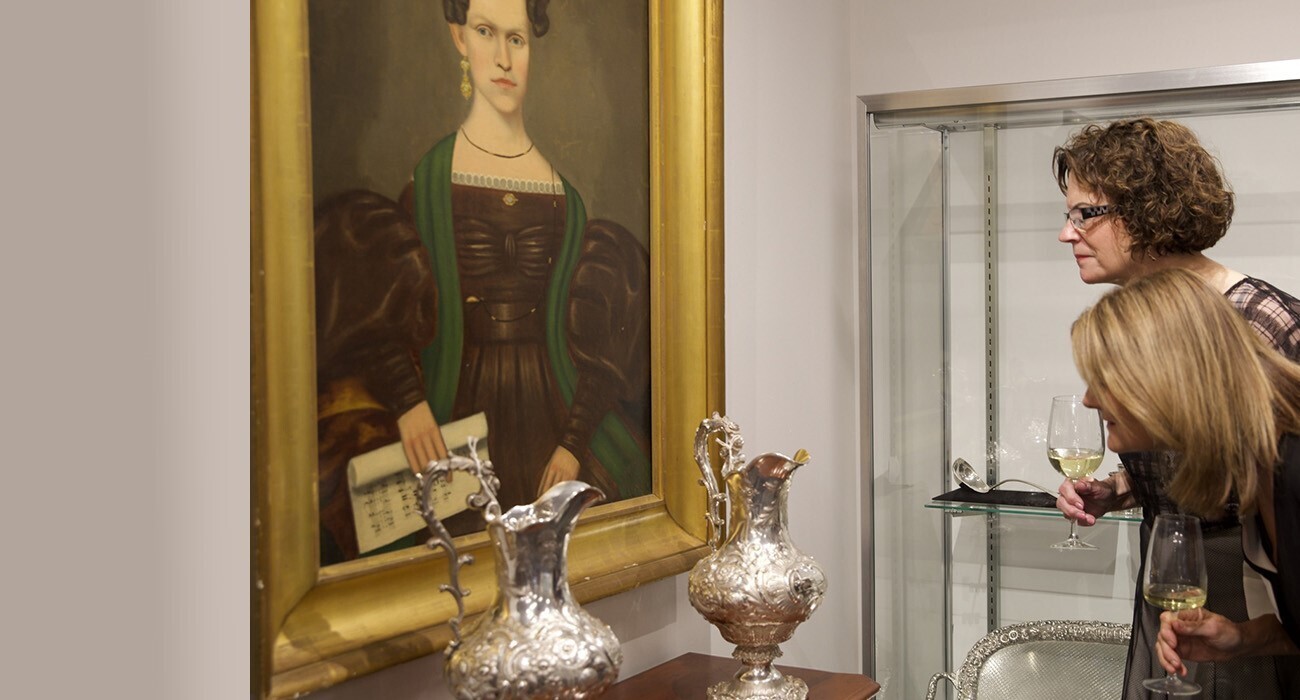 Two people looking at artwork of woman